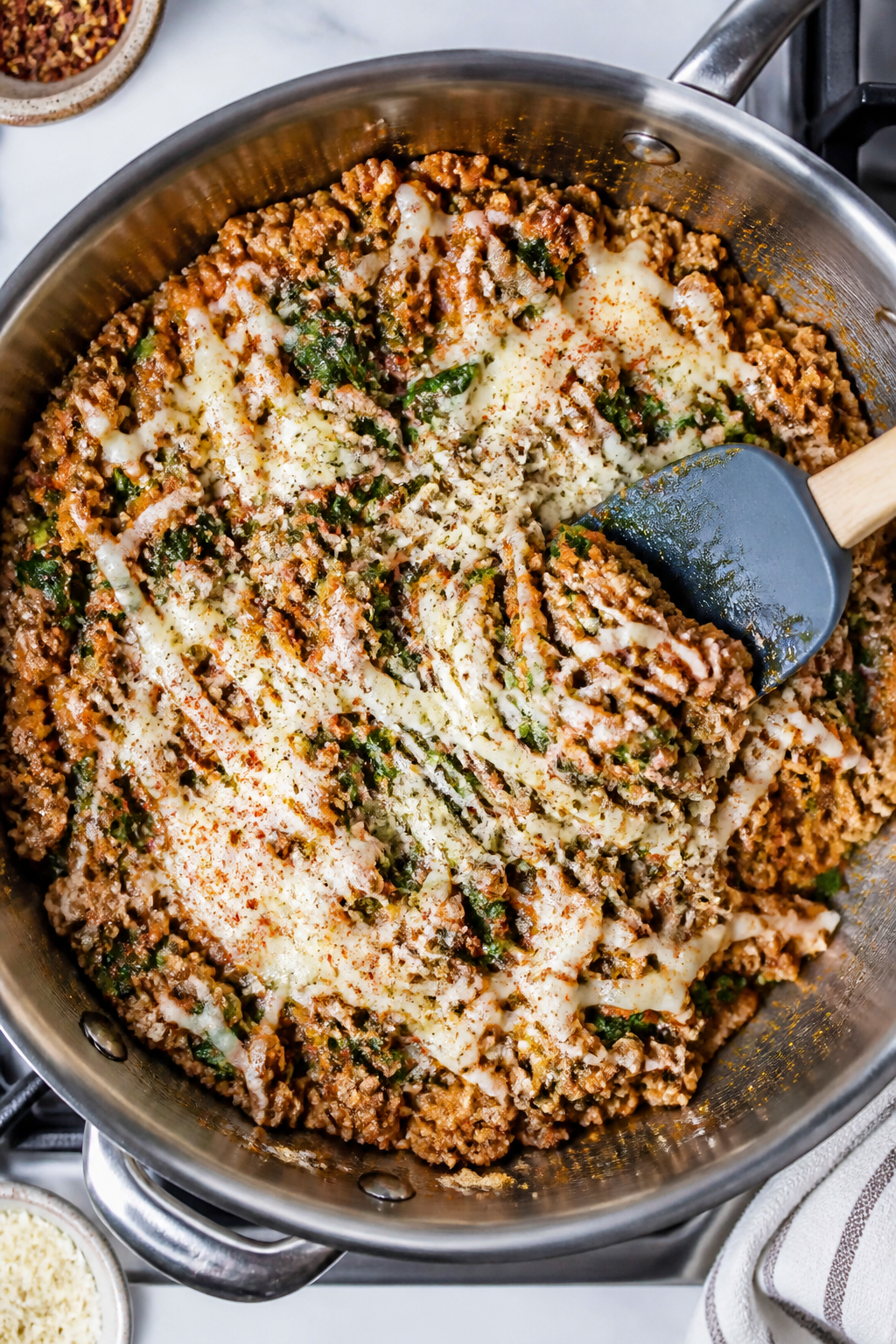 Cooking process: Overhead shot of the turkey filling simmering in a wide skillet—crumbled browned