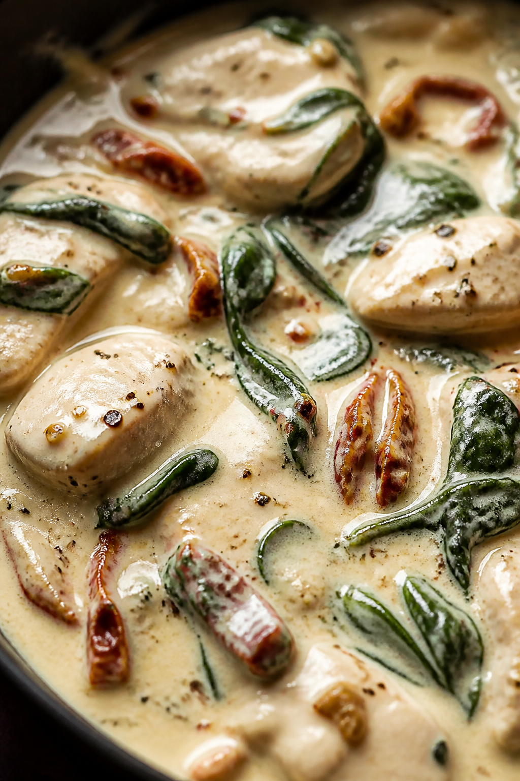 Creamy sauce detail: Extreme close-up of the silky Tuscan cream sauce in the skillet after Parmesan 