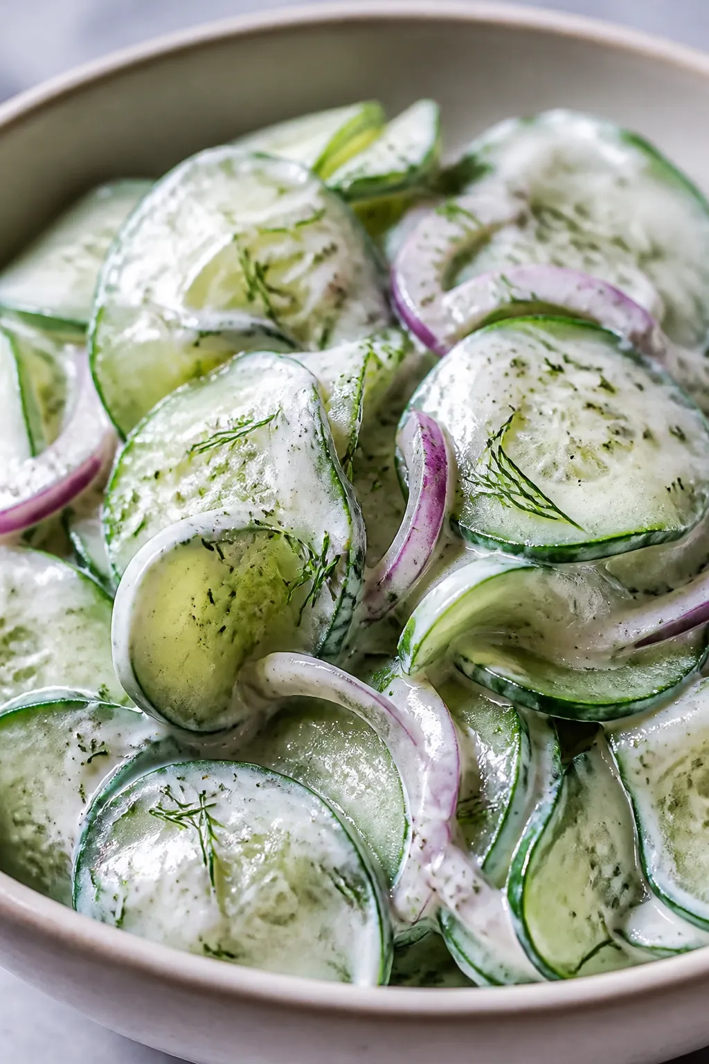 Close-up detail: Thinly sliced, salted-and-dried English cucumber rounds folded in a creamy keto dre