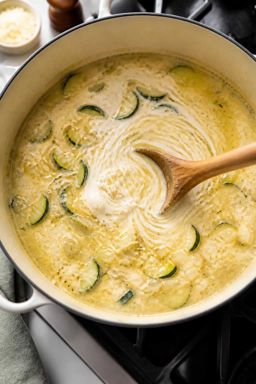 Cooking process: Over-the-shoulder top-down shot of the soup at the “add cream and cheese” stage