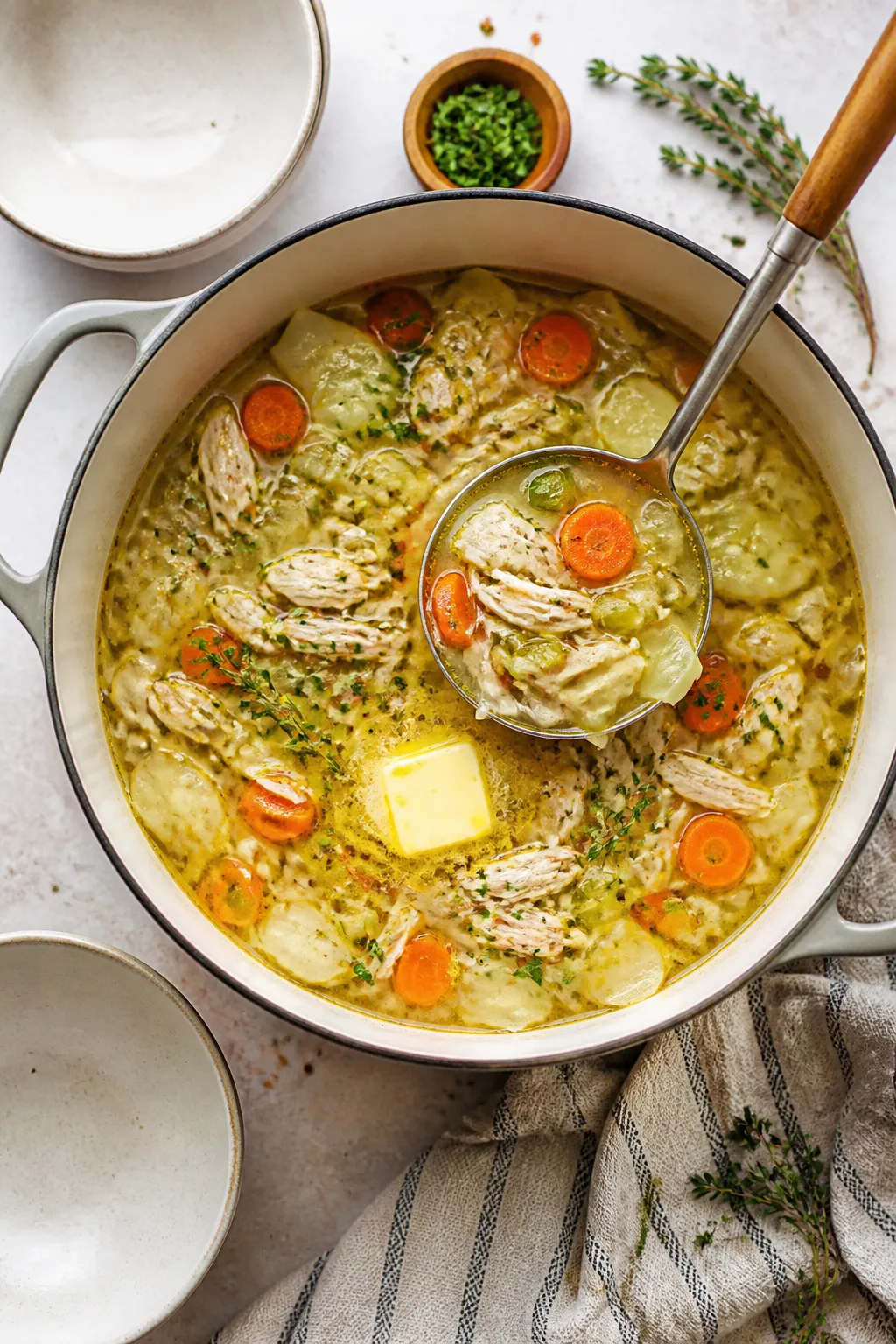 Tasty top view, overhead: Overhead shot of a family-style pot and a ladle poised above it, capturing