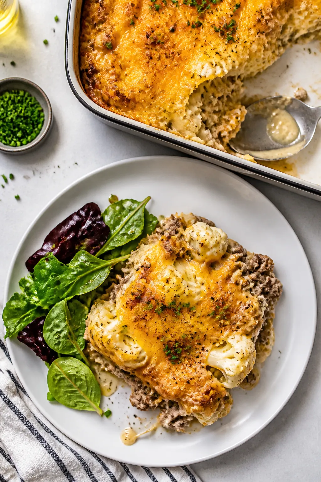 Tasty top view: Overhead shot of a neatly scooped square of keto ground beef and cauliflower cassero