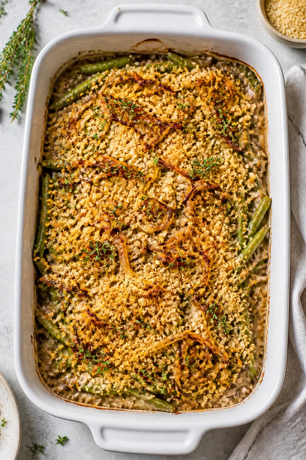 Tasty top view: Overhead shot of the baked Keto Green Bean Casserole in a 9x13 ceramic dish—vibran
